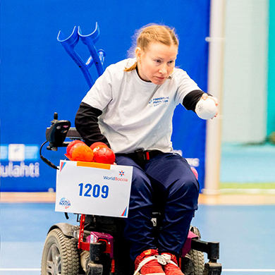 Saila Luumi heittää palloa Pajulahden Challenger -turnauksessa taustallaan kisan mainoslakana seinällä.